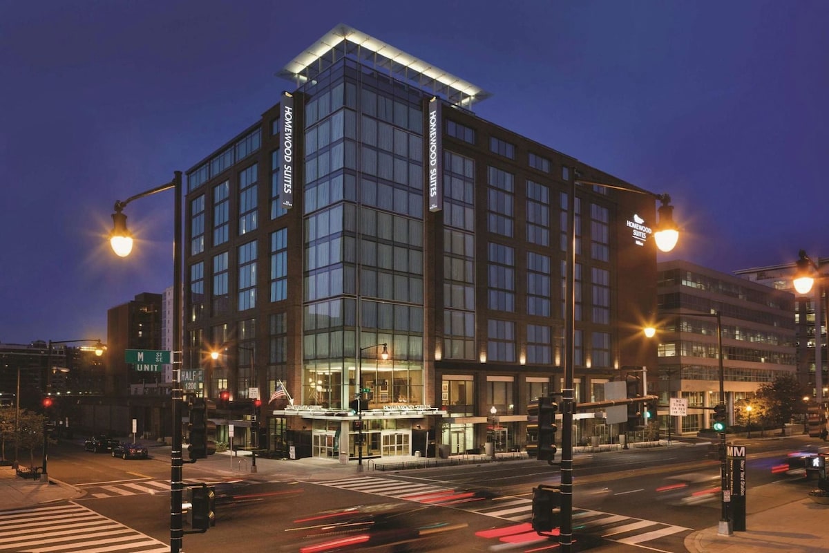 Een modern hotel met een glazen gevel, meerdere verdiepingen en een opvallende entree.