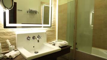 A bathroom with a sink, mirror, and shower.