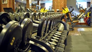 A gym with rows of dumbbells and exercise equipment.