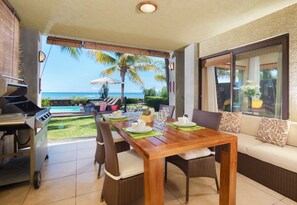 A dining area with a view of the ocean, a grill, and a sofa. - Bel Azur Beach Residence with LOV (Pointe Aux Piments)