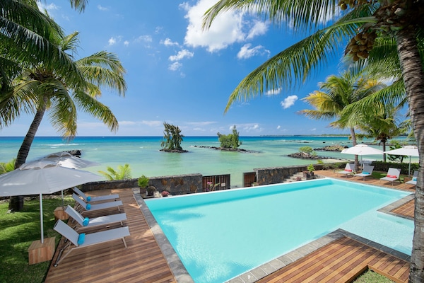 Een buitenzwembad, parasols voor strand/zwembad