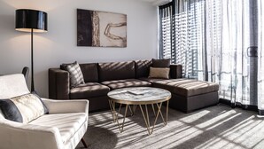 Una sala de estar moderna con un sofá modular, una mesa de centro redonda y una lámpara de pie.