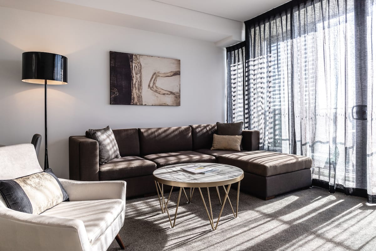 A modern living room with a sectional sofa, a round coffee table, and a floor lamp.
