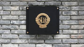 Una placa con un logotipo y texto en una pared de ladrillo.