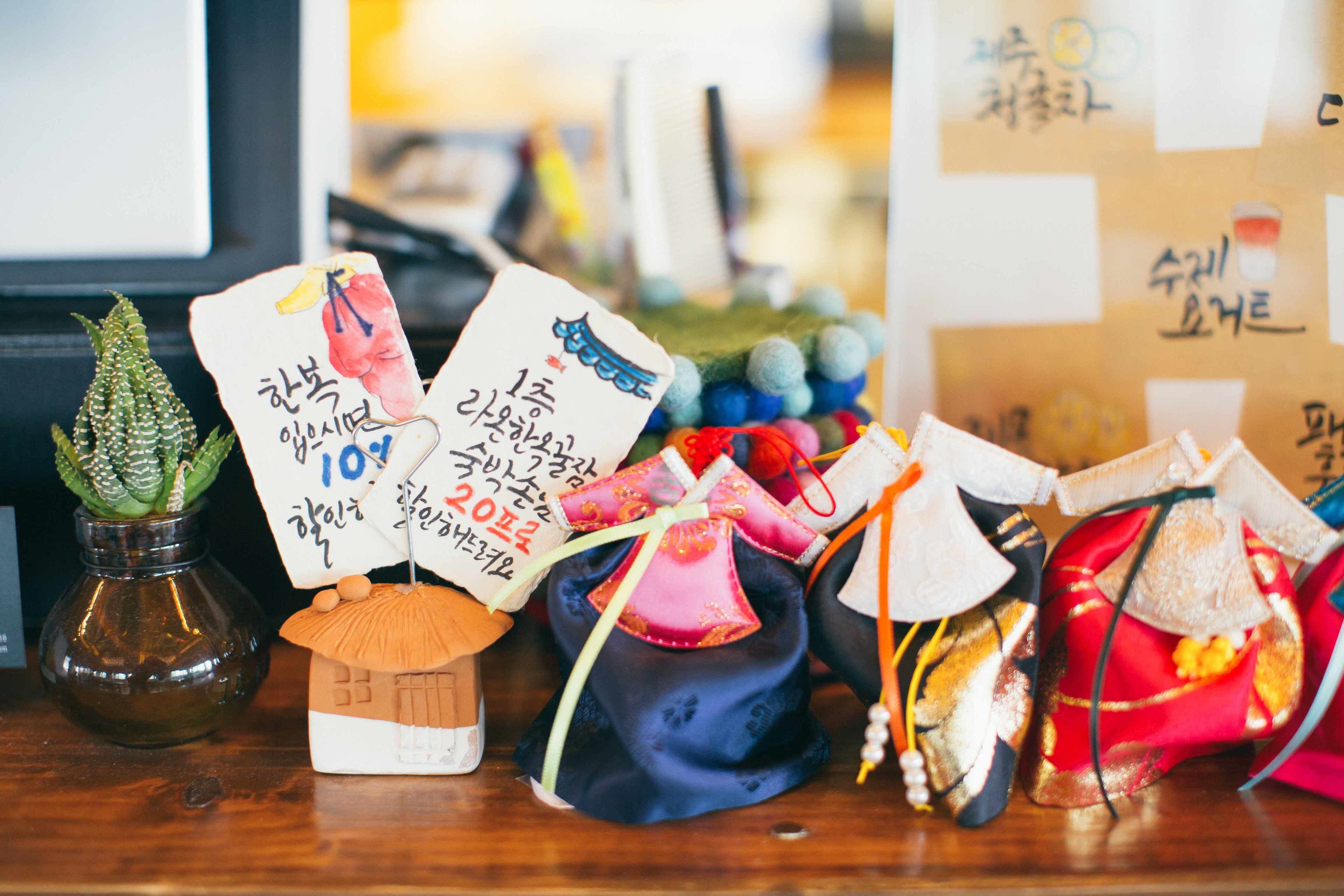 A display of traditional Korean hats and a small house model with Korean text.