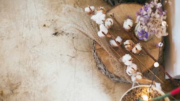A rustic wooden surface with cotton plants and dried flowers.