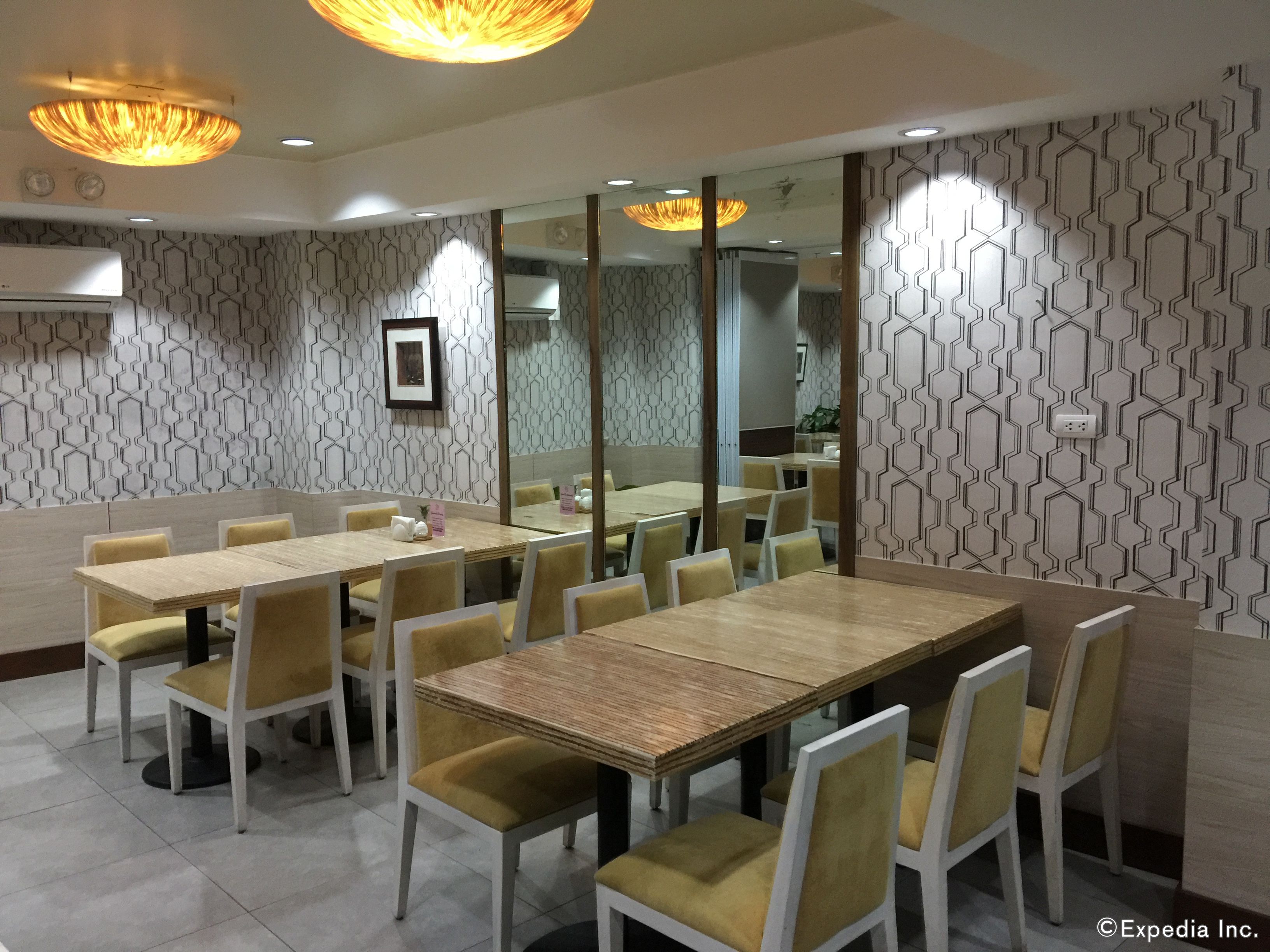 Un salón de conferencias con una larga mesa y sillas, paredes con diseño y luces en el techo.