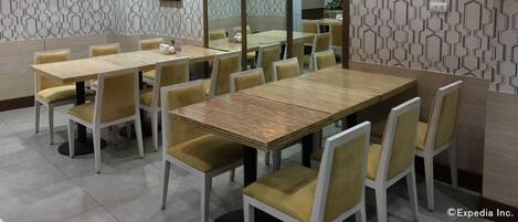 Un salón de conferencias con una larga mesa y sillas, paredes con diseño y luces en el techo.
