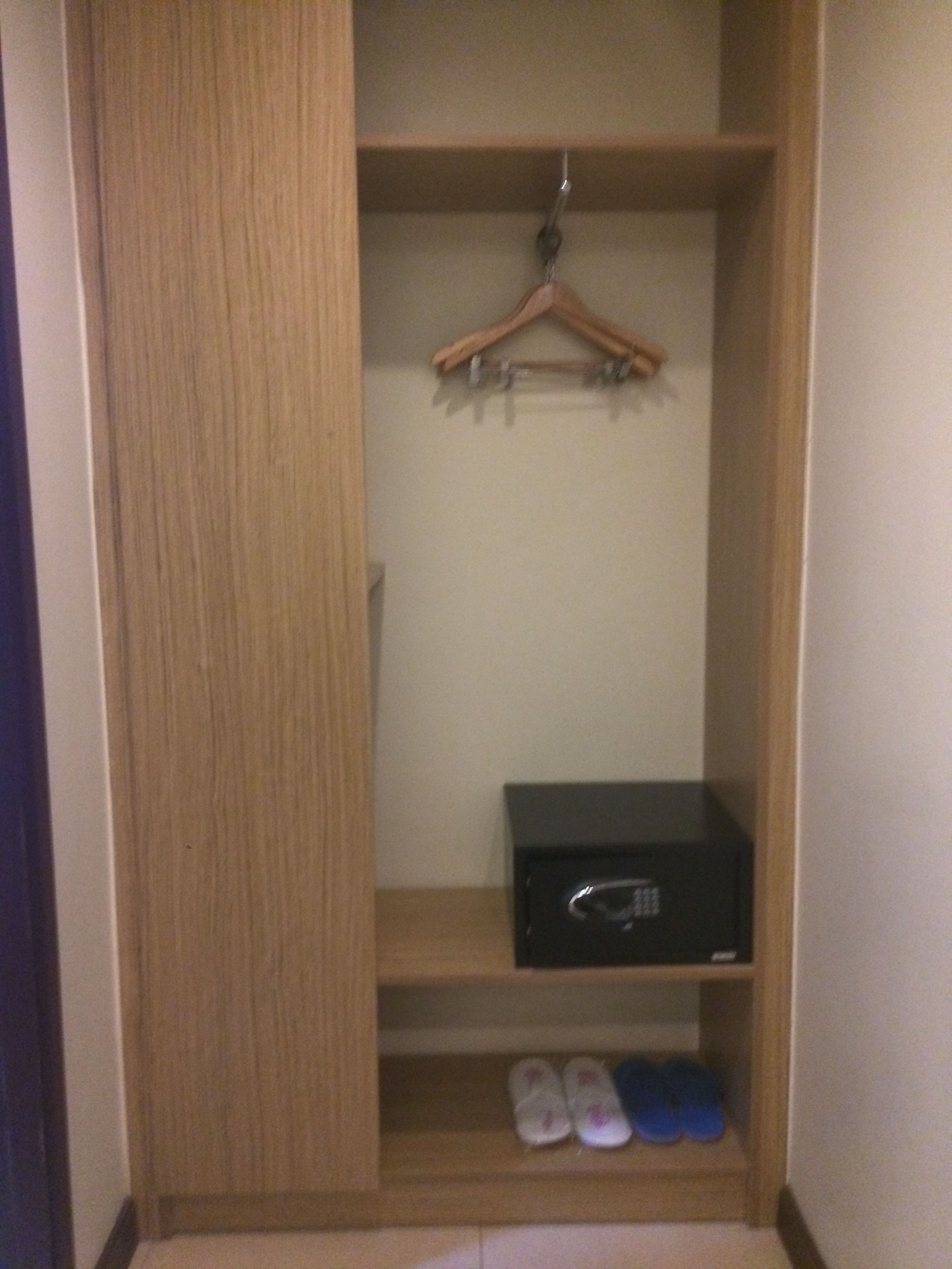A wooden wardrobe with a hanging rod and shelves.
