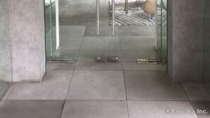 A modern lobby with a glass elevator, potted plants, and a seating area. - Belian Hotel (Tagbilaran)