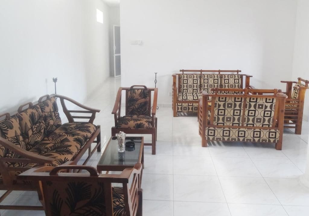 A room with a sofa, chairs, and a table.