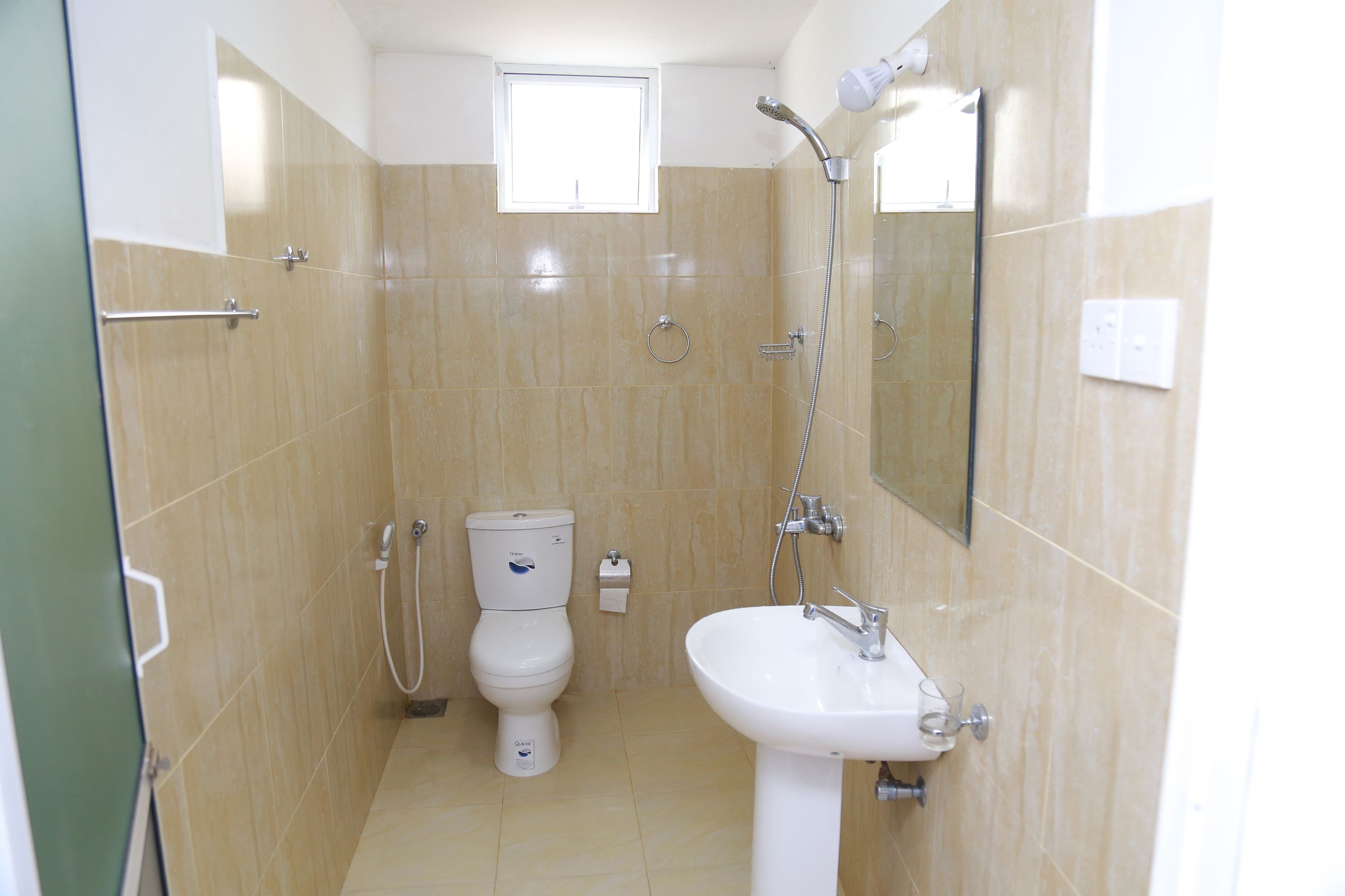 A bathroom with a toilet, sink, and shower.