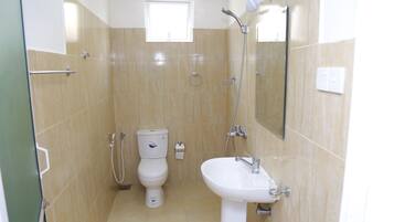 Un baño con inodoro, lavamanos y ducha.