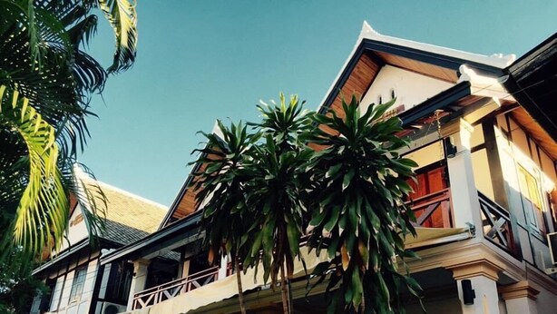 A two-story building with a balcony and a staircase. - Nocknoy Lanexang Guesthouse (Luang Prabang)