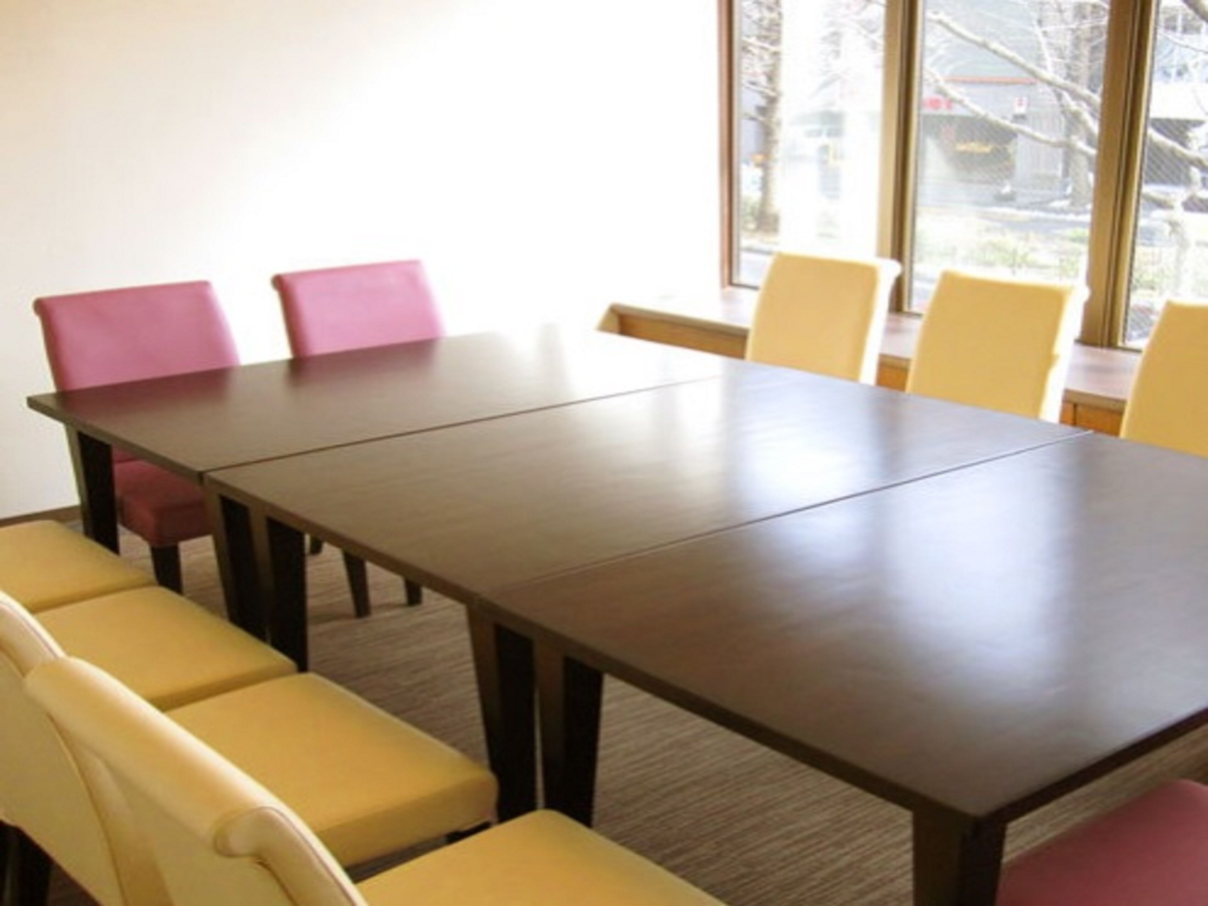 A conference room with a long table and multiple chairs.