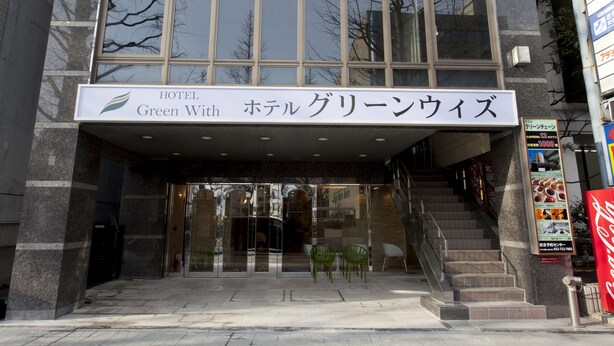 The entrance of the HOTEL Green With a glass facade and a sign in both English and Japanese. - Hotel Green With (Sendai)