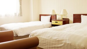 A hotel room with two single beds, a wooden nightstand with lamps, and a window with curtains. - Hotel Green With (Sendai)