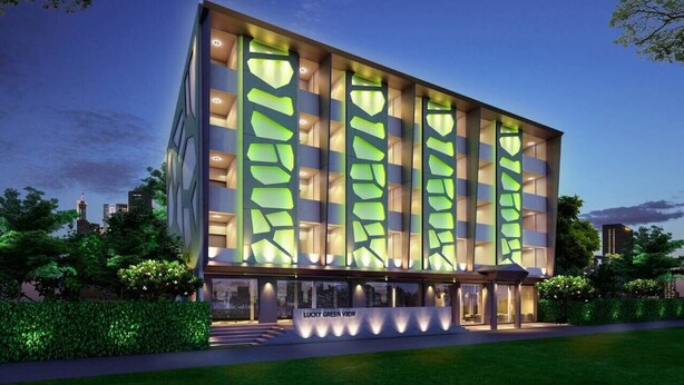 Un edificio moderno con fachada de vidrio y un cartel que dice 'LUCKY GREEN VIEW'.