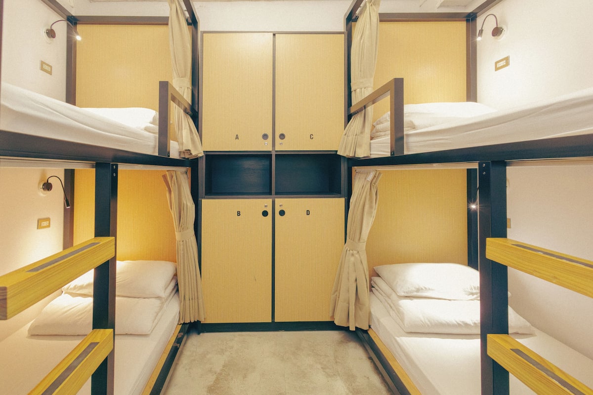 A bunk bed room with a wardrobe, a mirror, and a light fixture.