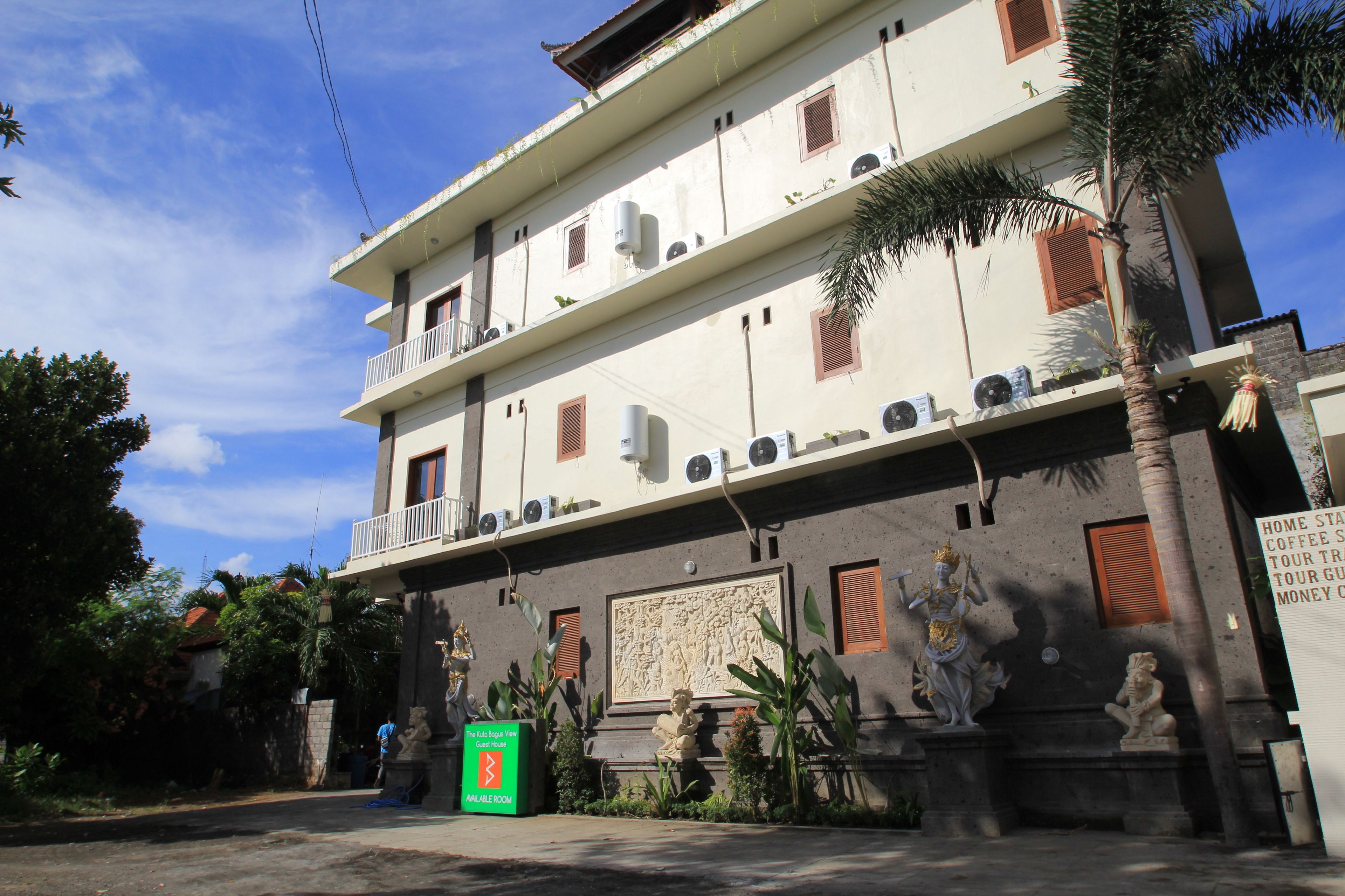 Un edificio de varios pisos con balcones, unidades de aire acondicionado y estatuas.