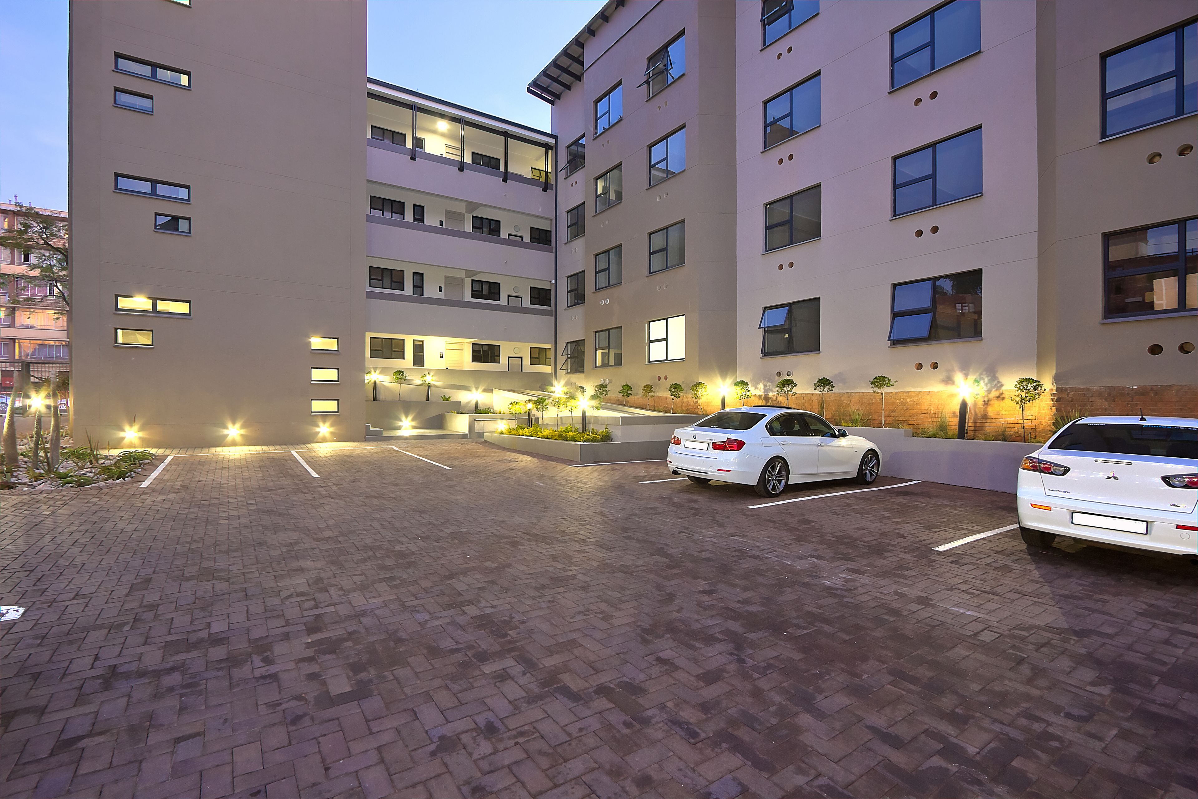 A multi-story parking garage with two white cars parked.