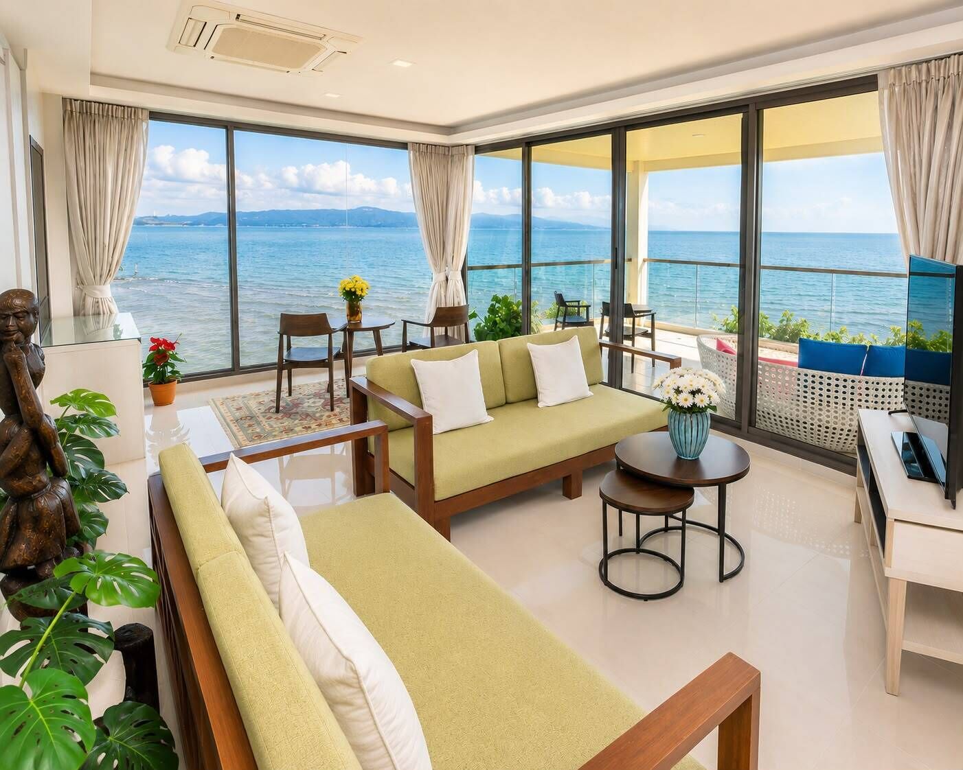 Un balcón amplio con vista al mar, amoblado con un sofá, sillas y una mesita.
