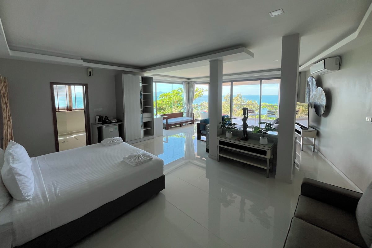 Una camera d'albergo moderna con un ampio letto, una scrivania e vista sull'oceano.