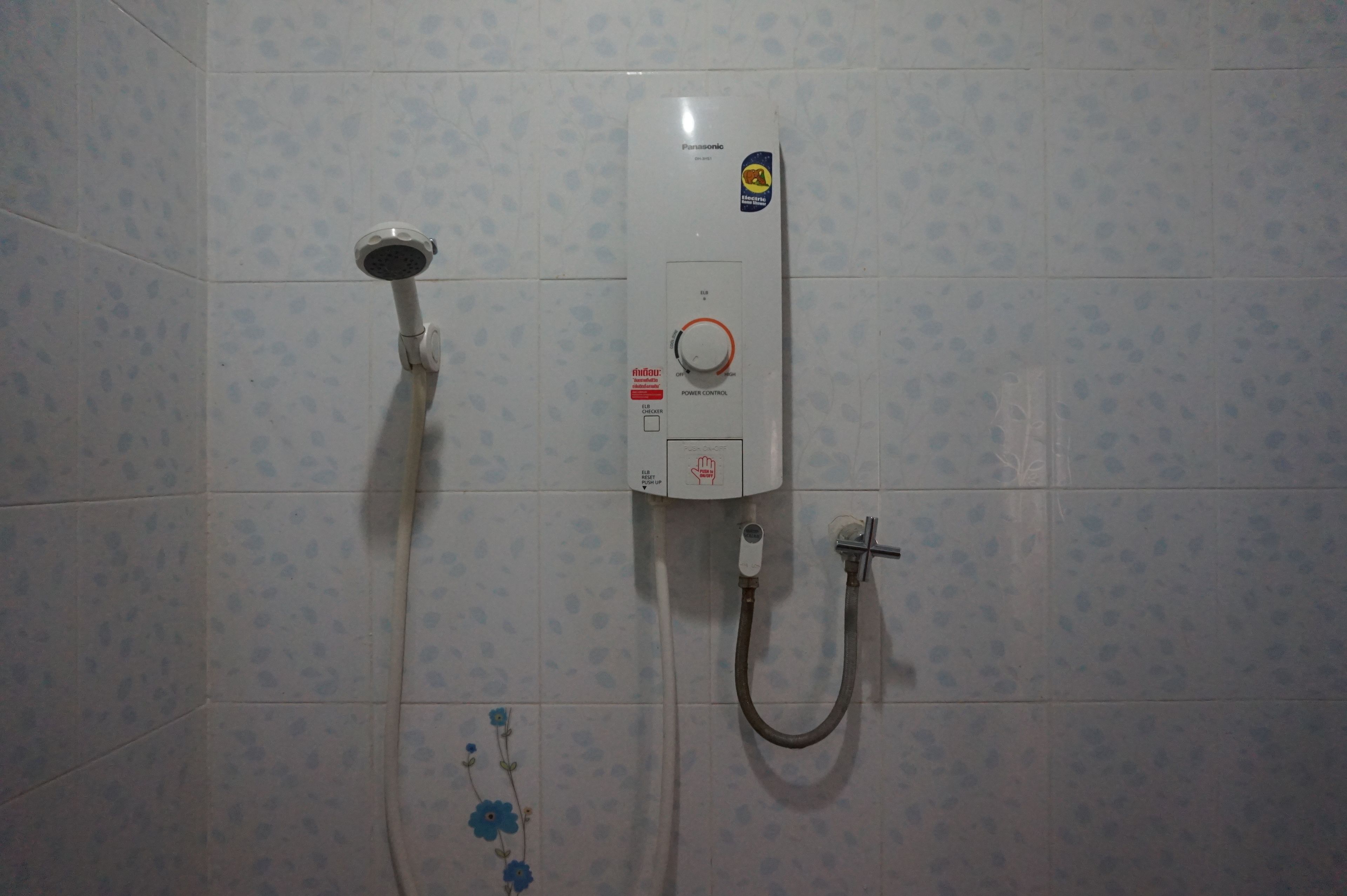 Un baño con ducha empotrada, cabezal de ducha manual y manguera de ducha.