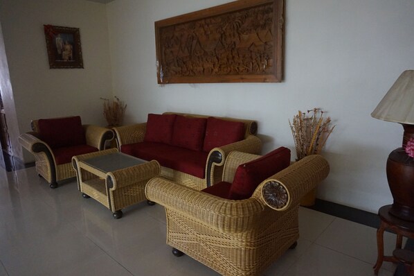 A living room with a sofa set, a coffee table, and a lamp.