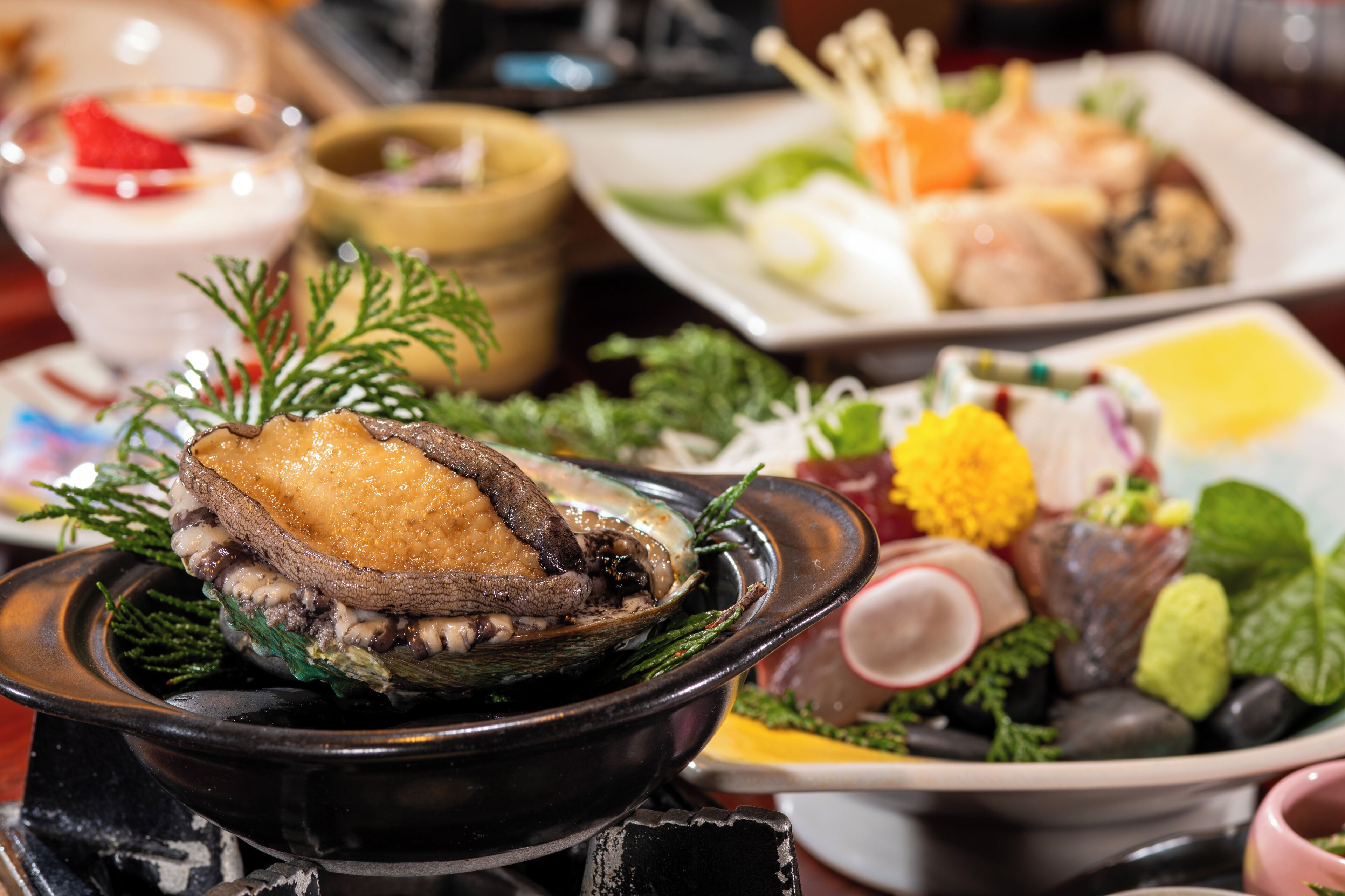 A variety of dishes including a roasted meat dish, seafood, and vegetables, suggesting a diverse menu.