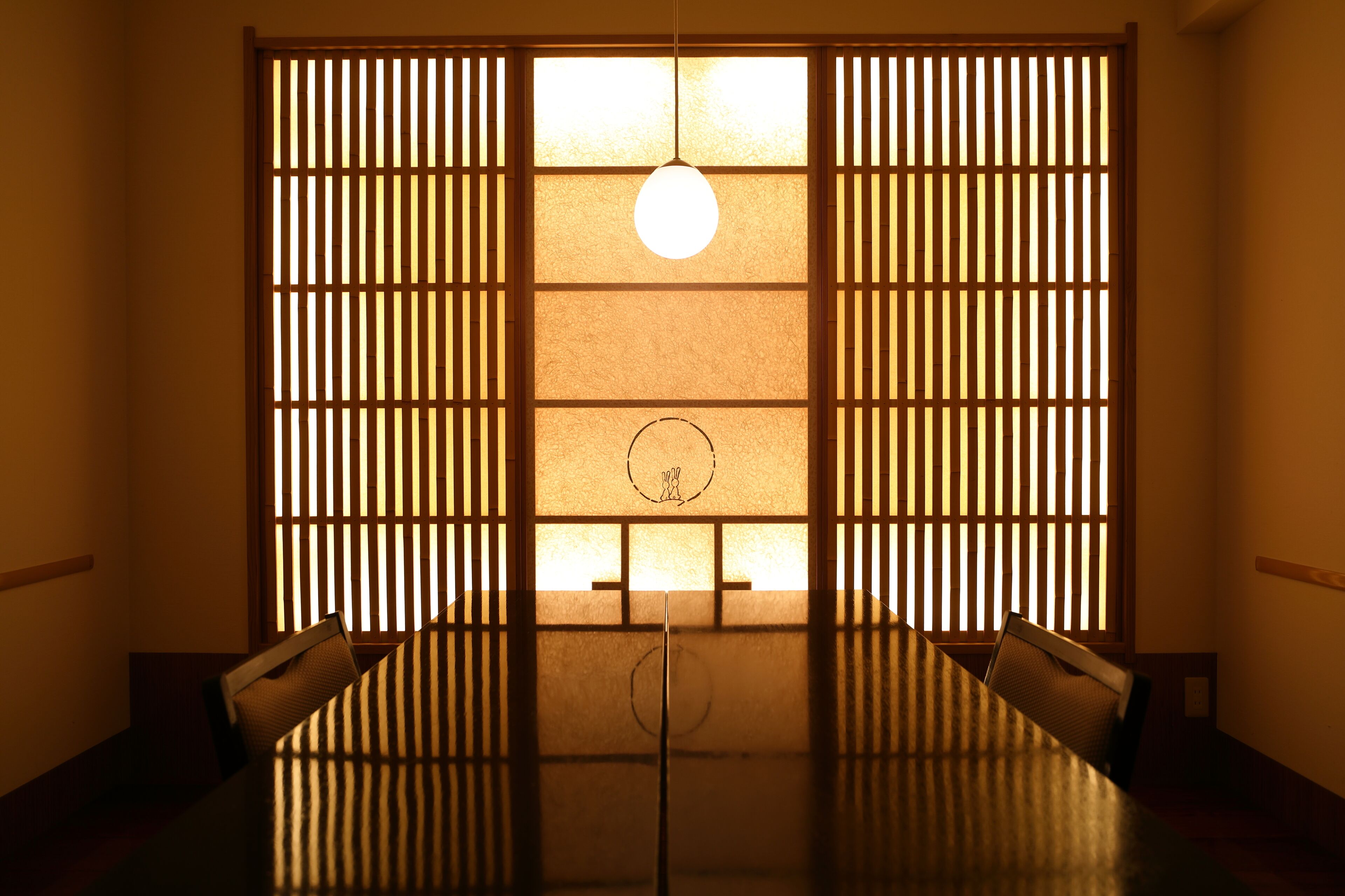 Une pièce de style japonais traditionnel, avec un sol recouvert de tatamis, une table basse et des portes coulissantes.