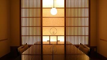 Une pièce de style japonais traditionnel, avec un sol recouvert de tatamis, une table basse et des portes coulissantes.