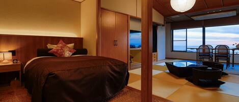 Een slaapkamer met een groot bed, houten plafond en uitzicht op zee door een groot raam.