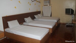 A hotel room with two single beds, a wooden headboard, a wall-mounted TV, and a window with a curtain. - Park Bed and Breakfast Hotel Pasay (Pasay)