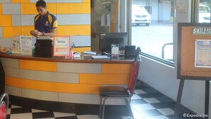 A reception desk with a clock, a computer, and various informational posters. - Park Bed and Breakfast Hotel Pasay (Pasay)