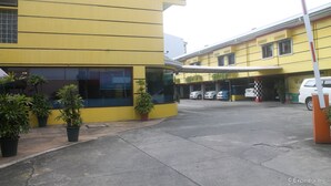 A yellow building with large windows and a covered entrance area. - Park Bed and Breakfast Hotel Pasay (Pasay)