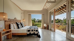 A bedroom with a large bed, a wooden headboard, a bedside table, a hanging lamp, and a view of a garden through a sliding glass door. - Villa Alea by Villa Finder (Kerobokan)