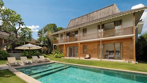A two-story house with a swimming pool, outdoor seating, and lush greenery. - Villa Alea by Villa Finder (Kerobokan)