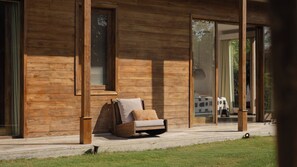 A modern wooden building with large glass doors leading to a covered outdoor area. - Villa Alea by Villa Finder (Kerobokan)