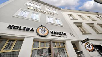A hotel named "Kapland City" with a sign for "Koliba Kamzík" below it, indicating a restaurant.