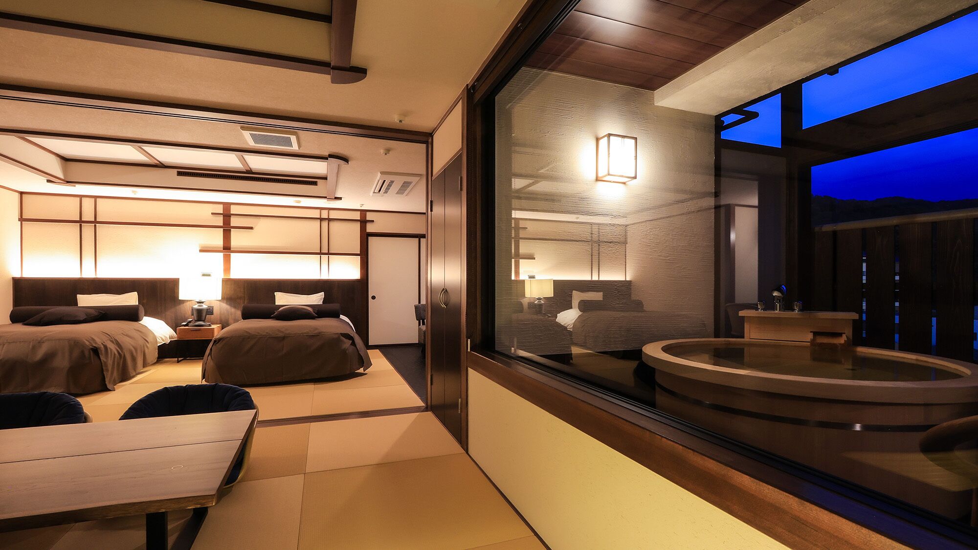 Una habitació d'hotel moderna amb un llit gran, una taula de treball i vistes a l'exterior.