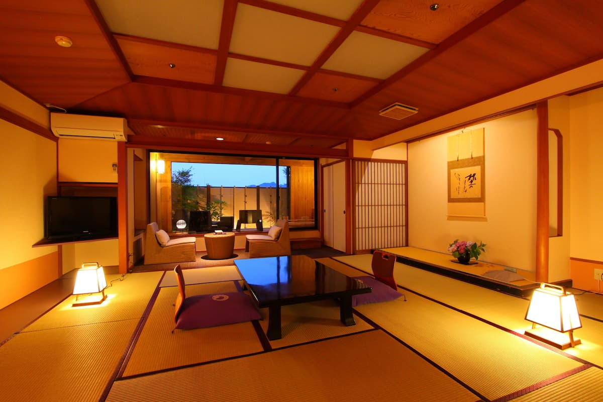 A traditional Japanese room with tatami flooring, a low table, and cushions.