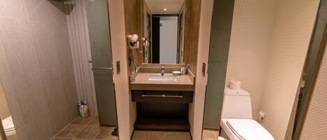 Un baño moderno con ducha, lavamanos e inodoro.
