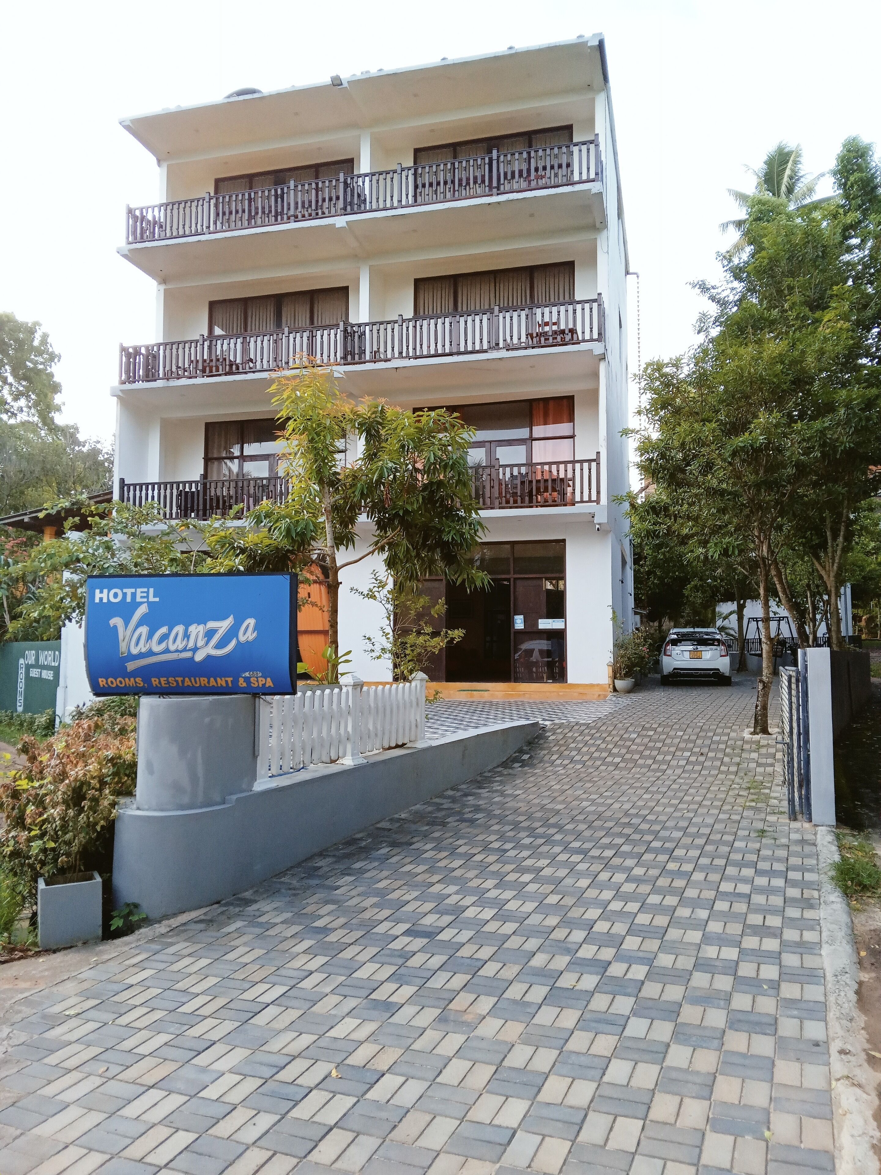 A hotel named 'Vacanza' with a signboard indicating it offers rooms, a restaurant, and a spa.