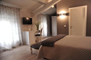 Una camera da letto con un letto, una scrivania, una sedia, una televisione e una porta.