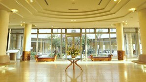 A spacious lobby with a central table, two sofas, and large windows offering a view of the outdoors. - Shirahama Coganoi Resort&Spa (Shirahama)