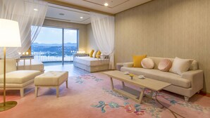 A spacious living room with a large window, a sofa set, a coffee table, and a decorative carpet. - Shirahama Coganoi Resort&Spa (Shirahama)