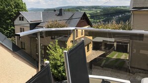 Ein Balkon mit freiem Blick auf Häuser und ein Tal.