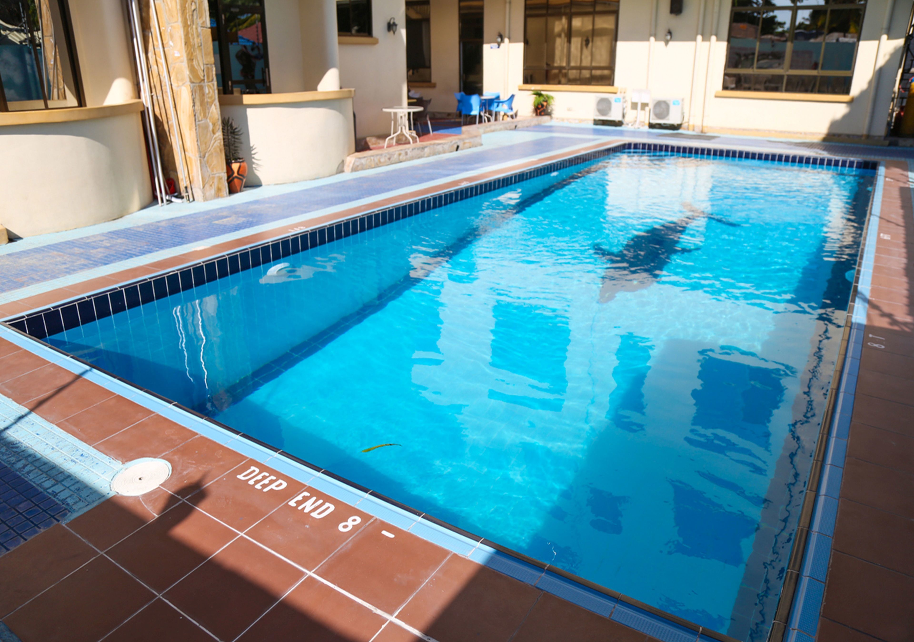 A swimming pool with tiled edges and a 'Deep End 8' marking.