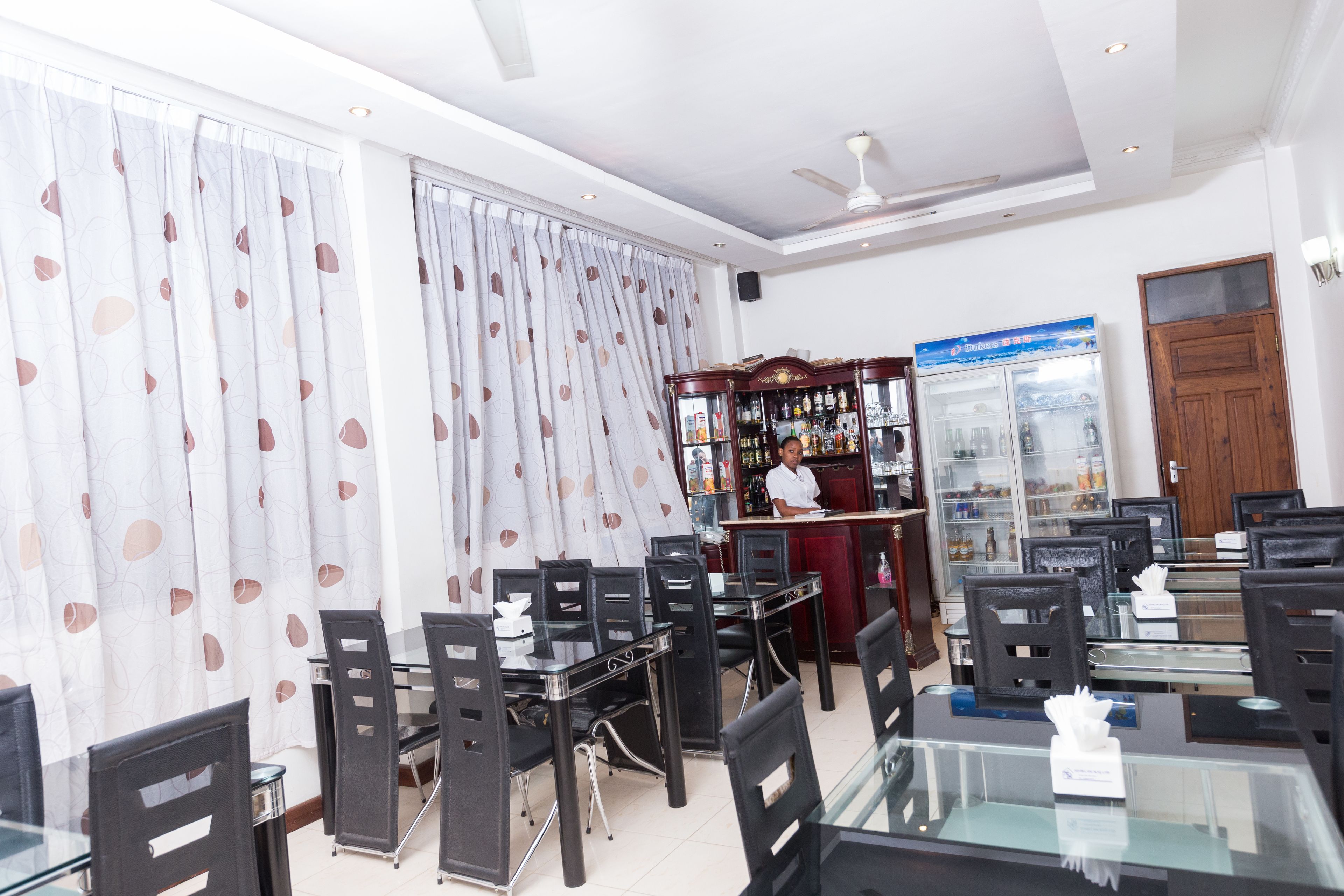 Un restaurant doté d’un bar, de tables et de chaises.